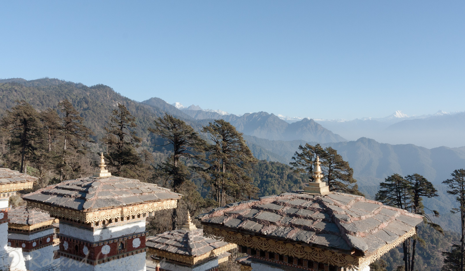 Le Druk Wangyal, ensemble impressionant de 108 chortens avec de hauts sommets de l'Himalaya à l'horizon.