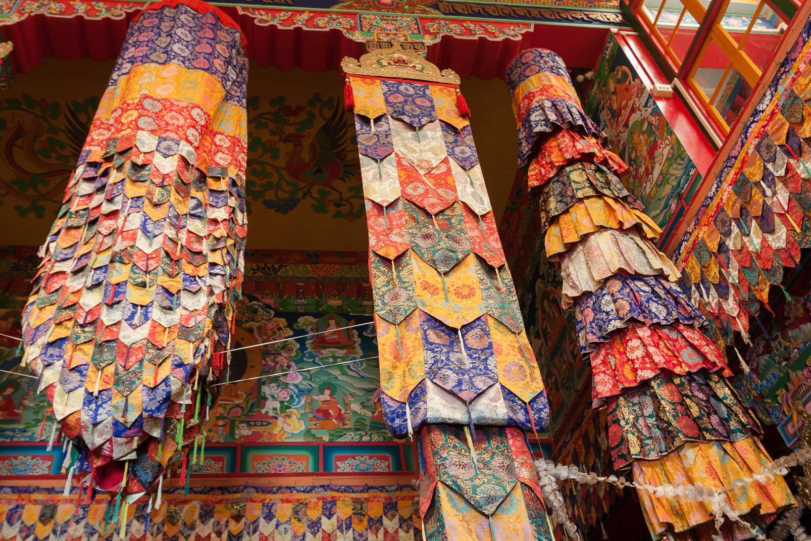 Monastère de Tharpa Choling. L'intérieur est richement décoré. Comme ces lanières de tissus.