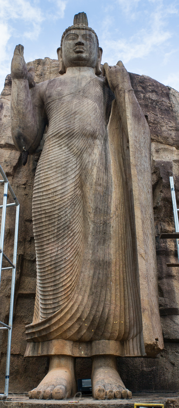 A Avukana, le bouddha du Soleil-Levant. La main droite est levée en signe de bénédiction. Son chignon avec une flamme est typique du style cingalais.