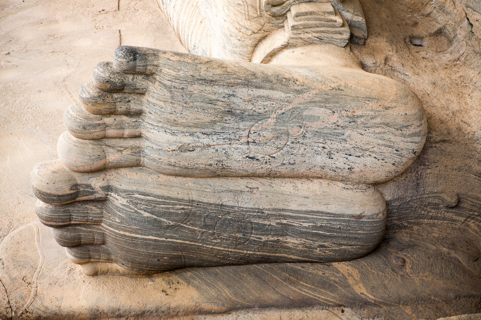 Gal Vihara. Le Bouddha couché long de 14 m. Détail des pieds et la roue solaire.