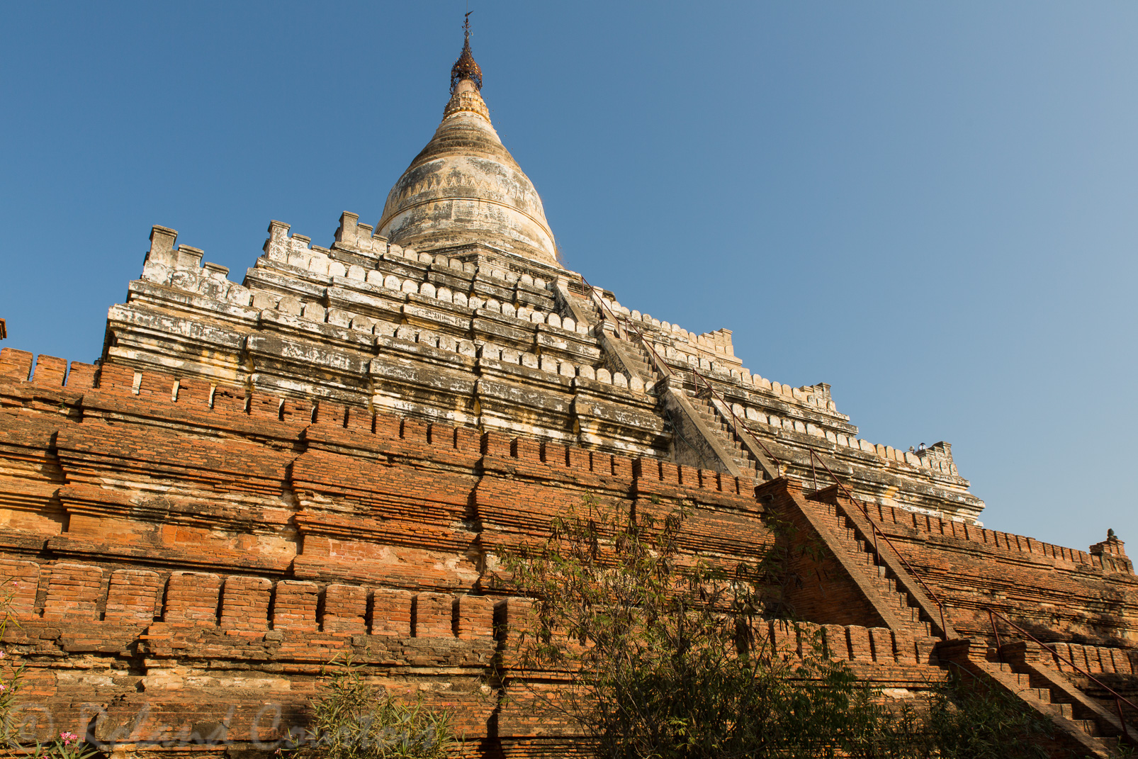 Pagode Shwehsandaw. L'escalier escarpé traverse 5 terrasses carrées (la terre) menant au stupa en forme de cloche (le ciel) reposant sur un socle octogonal.