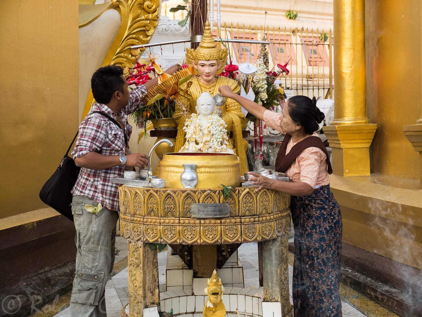 Pagode Shwedagon. Les pélerins arrosent des statues de divinités pour racheter leurs fautes et renaître dans les meilleures conditions.