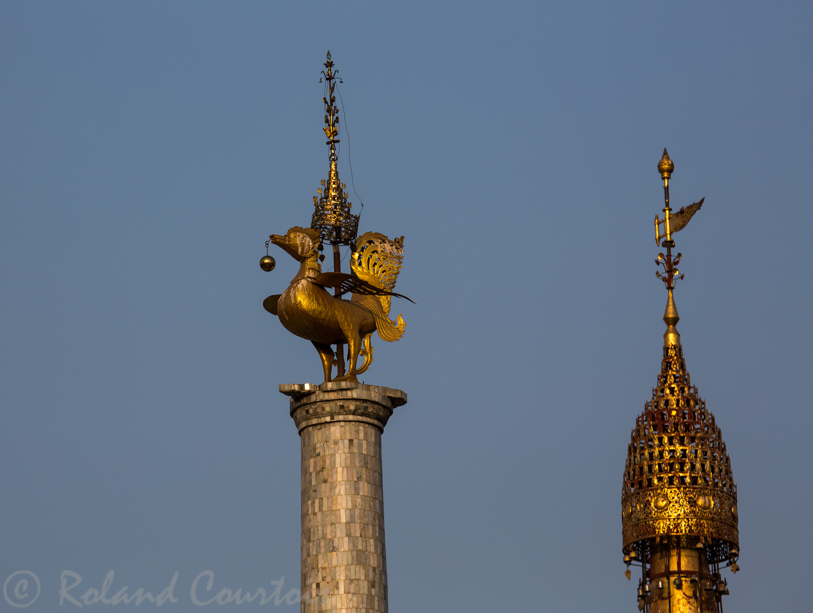 Chacun des petits stupas entourant le grand Shwedagon est également coiffé d'une ombrelle. Un phénix se retrouve sur une colonne.