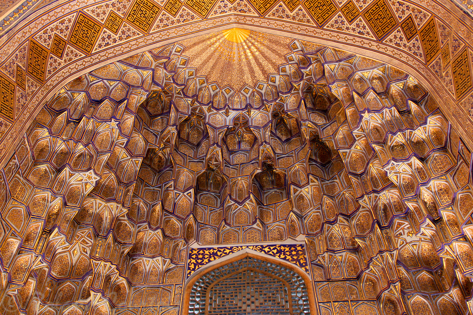 Le Gour Emir, mausolée de Tamerlan et de sa famille. Dans les niches, des motifs géométriques déploient un ciel étoilé de stalactites de papier maché peint en bleu et or.