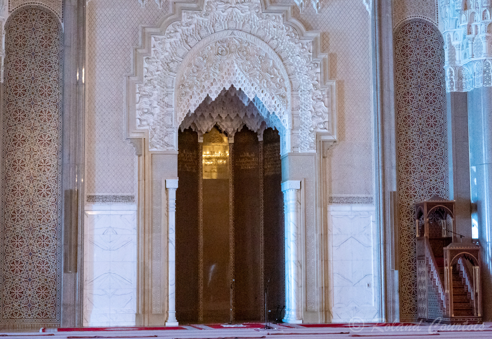 Le Mihrab en marbre blanc de Carrare, en zellige et plâtre, Et le minbar, une haute chaire utilisée comme prêchoir tous les vendredis ; elle est en acajou incrustée d'ivoire.