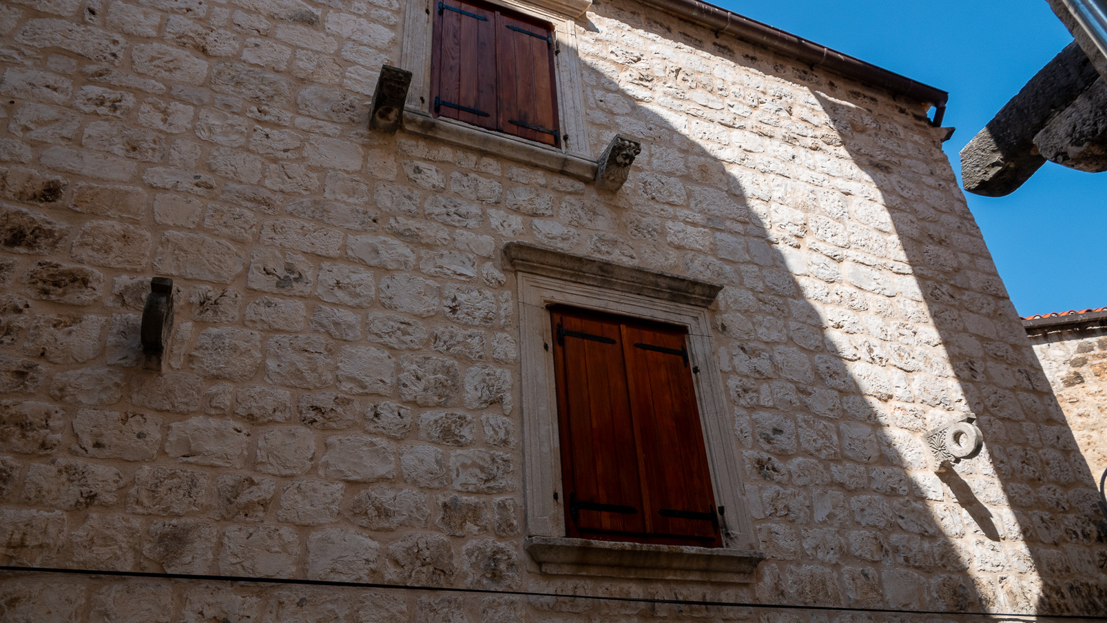 De chaque côté des fenêtres, des supports pour une barre 
sur laquelle un voile humide est accroché qui va rafraichir l'intérieur..